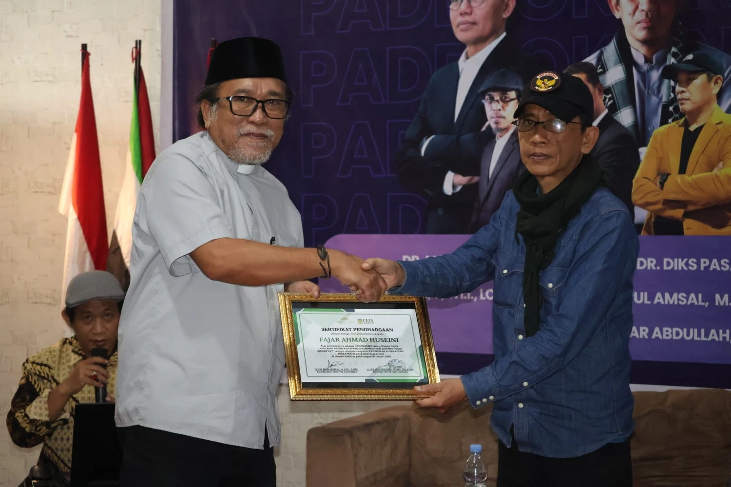 Pdt. Dr. Diks Pasande (kiri) menyerahkan sertifikat penghargaan kepada Fajar Ahmad Husein sebagai narasumber dalam rangkaian diskusi Padepokan Aufklärung VI di Al Hikmah Institute Makassar, Sabtu (10/1/2026).